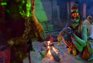 A Nepalese Hindu Sadhu paints coloured paste onto his face during the Mahashivaratri festival in Kathmandu