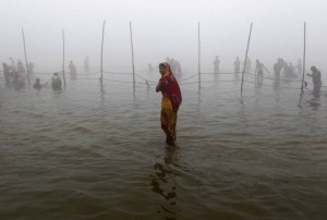 A devotee waits for a relative as she arrives to take a holy dip in Sangam during the Mahashivratri festival in Allahabad