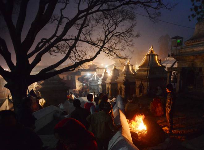 Nepalese Hindu worshippers warm themselves near a fire during the Mahashivaratri festival in Kathmandu