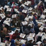 Spectators use catalogues to protect themselves from rain as they watch the Republic Day Parade in New Delhi on January 26, 2015