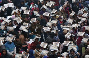 Spectators use catalogues to protect themselves from rain as they watch the Republic Day Parade in New Delhi on January 26, 2015