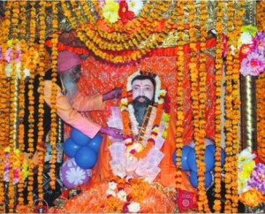 A priest garlands an idol of Guru Ravidas on the 638th birth anniversary of the saint at a temple in Amritsar