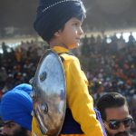 A Sikh child watches revelers at the Hola Mohalla festival at Anandpur Sahib on March 13, 2017