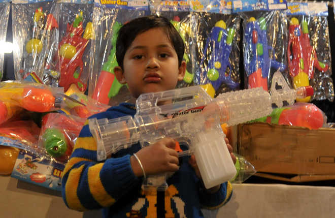A child holds an electronic pichkari at a shop in Sector 22 Chandigarh