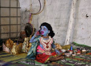 A young artiste dressed as Hanuman speaks on a mobile phone before his performance on occasion of Hindu festival of Ram Navami inside a temple in Bengaluru