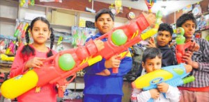 Children carry water guns at a shop in Ludhiana