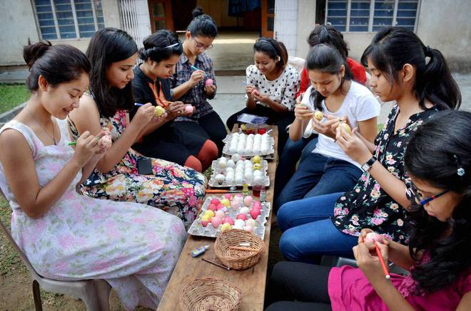 Christian girls decorate eggs on the eve of Easter in Guwahati