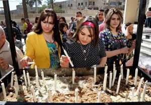 Iraqis women light candles after the Palm Sunday service at Lady Deliverance Church in Baghdad Iraq