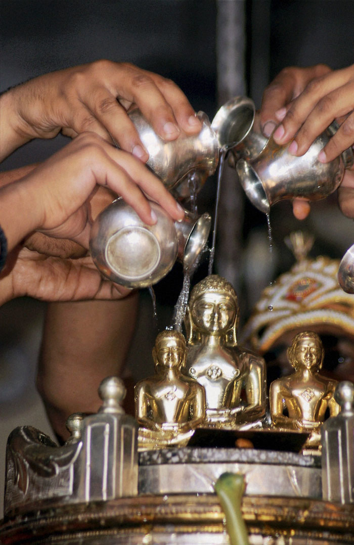 Jain devotees offer water to idols of Lord Mahavir on the occasion of Mahavir Jayanti in Mirzapur
