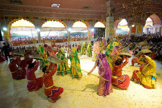 Men and women playing Lathmar Holi during the Fag Mahotsava at the Govind Devji Temple in Jaipur