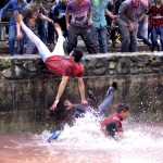 Panjab University students throw their friends in the pond while celebrating Holi on the university campus