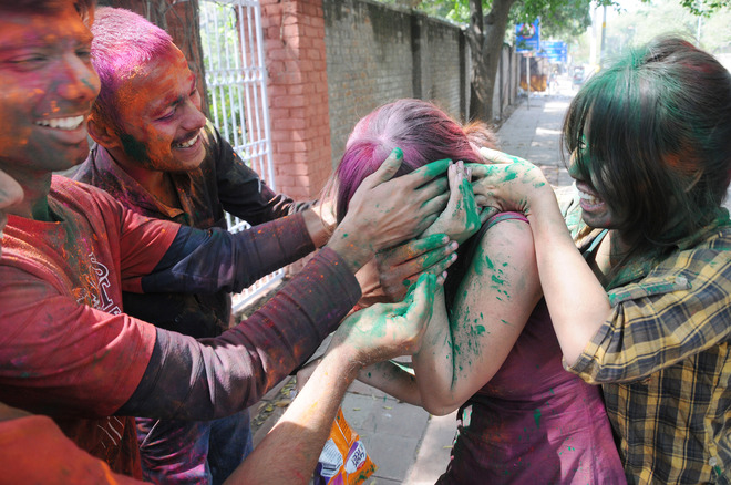 Students of Delhi University daubed in colours on the eve of Holi celebration in New Delhi