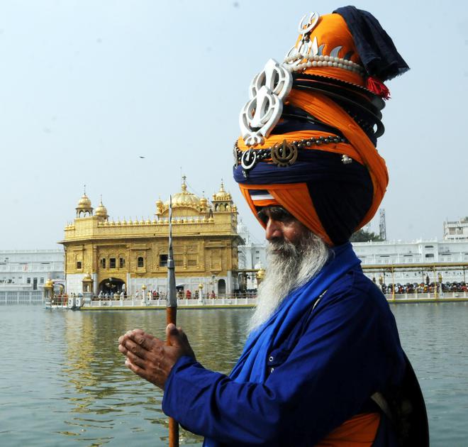 Sikh Nihang Sikh religious warrior pay obeisance at the Golden Temple in Amritsar on the Baisakhi on April 14, 2015