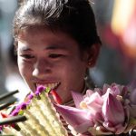 A Cambodian vendor holds flowers during the Buddhist Visak Bochea