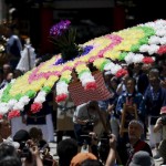 A local resident carries a flower umbrella to lead a portable shrine at the Kanda-Myojin shrine during the Kanda festival in Tokyo, Japan, on May 10, 2015. The festival dating back to the Edo period is one of the three major festivals in Tokyo.