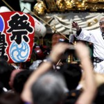 A local resident performs on a portable shrine before he leads it into the Kanda-Myojin shrine during the Kanda festival in Tokyo, Japan, on May 10, 2015.