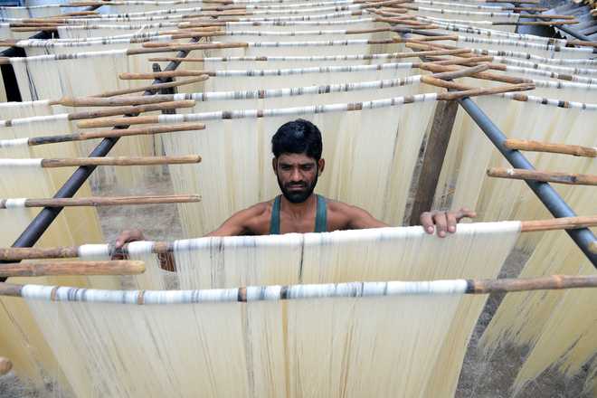 An Indian worker removes dried Seviiyan (thin vermicelli) that is used for the preparation of 'sheerkhorma', a traditional sweet dish prepared by the Muslim community during the holy month of Ramadan, at a food factory in Hyderabad