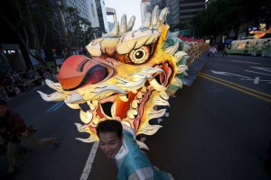Buddhist believers march with a dragon-shaped lantern during a lotus lantern parade in celebration of the upcoming birthday of Buddha in Seoul, South Korea, on May 16, 2015.