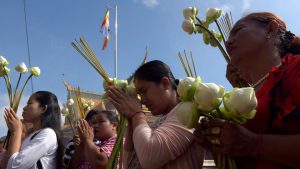Cambodian women pray in front of a shrine out side the Royal Palace in Phnom Penh. Sermons on the life and teachings of Buddha are held and attended by followers in larger numbers