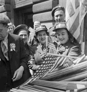 Canadian soldiers and members of the Canadian Women's Army Corps (CWAC) buy flags to wave in the VE-Day celebrations, in London May 8,1945