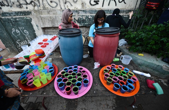 Egyptian volunteers distribute free juice in the street in Cairo during the Muslim holy fasting month of Ramadan