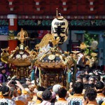 Local residents carry portable shrines into the Kanda-Myojin shrine in downtown Tokyo during the shrine's summer festival, called the Kanda Matsuri on May 10, 2015.
