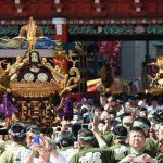 Local residents carry portable shrines into the Kanda-Myojin shrine in downtown Tokyo during the shrine's summer festival, called the Kanda Matsuri on May 10, 2015.
