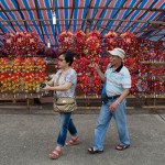 In this picture taken on May 10, 2015, a couple walk past a stall selling wind chimes at Joss House temple to celebrate the Tin Hau festival in Hong Kong.