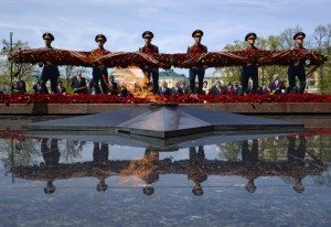 Russian President Vladimir Putin (background centre R), Kazakh President Nursultan Nazarbayev (background centre L), heads of foreign delegations and honorary guests watch soldiers during a wreath laying ceremony at the Unknown Soldier Tomb on the Victory Day in central Moscow, Russia, on May 9, 2015.