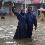 A couple clicks selfie on a water logged road after heavy rains in Mumbai