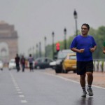 A couple jogs on the Rajpath in the rain in New Delhi on June 14, 2015