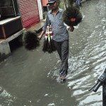 A vendor walks across a waterlogged street after heavy rains in Patiala on June 14, 2015