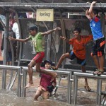 Children enjoy the rains on a waterlogged road of Mumbai on June 14, 2015