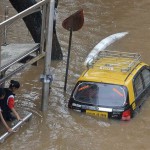 Indian pedestrians wade through a waterlogged neighbourhood in Mumbai on June 19, 2015. Heavy monsoon showers lashed India's financial capital resulting in waterlogging in low-lying areas of the city disrupting normal life