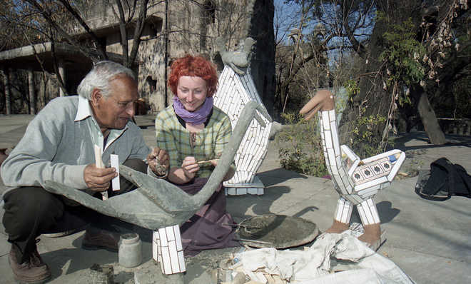Nek-Chand-showing-how-to-create-sculptures-to-a-tourist-at-Rock-Garden-in-Chandigarh