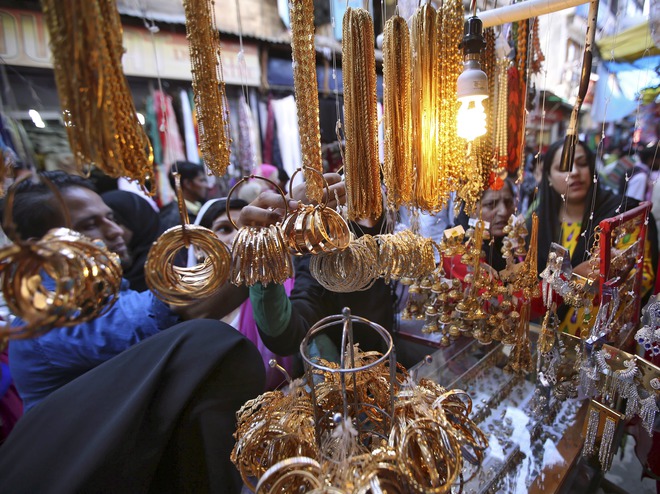 Women select jewellery before buying from a vendor at a marketplace ahead of the Eid al-Adha festival in Srinagar on September 23, 2015