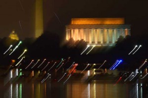People watch from their boats the fireworks over the Lincoln Memorial, Washington Monument and US Capitol in celebration of Independence Day in Washington, DC on July 4, 2015.
