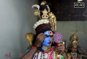A man dressed as Hindu God Ardhnarishwar gets ready to take part in a performance during festivities marking the start of the annual harvest festival of ‘Onam’ in Kochi on August 19, 2015