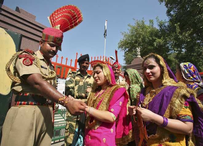 A woman ties a ‘rakhi’ onto the wrist of Border Security Force soldier during the Raksha Bandhan celebrations at the India-Pakistan joint check post at the Wagah border on the outskirts of Amritsar on August 29, 2015