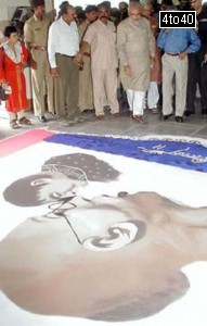 Former President APJ Abdul Kalam (R) stands beside Gujarat Chief Minister Narendra Modi and other officials while observing a painting of Mahatma Gandhi during his visit to Ahmedabad on August 12, 2002.