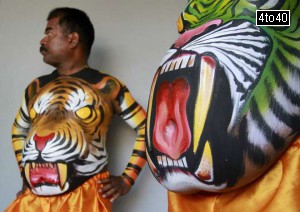 Dancers in body paint wait to take part in a performance during festivities marking the start of the annual harvest festival of ‘Onam’ in Kochi on August 19, 2015