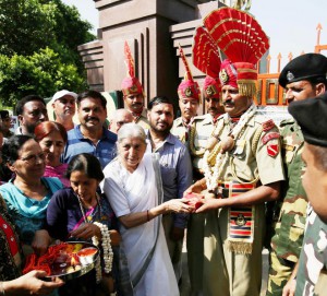Former Punjab minister Laxmi Kanta Chawla (centre) ties a 'rakhi' to the wrist of a Border Security Force (BSF) soldier at the India-Pakistan Wagah border joint post Attari on August 29, 2015
