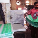 Labourer working at a printing press busy in printing national flags bunting on arrival of Pakistan Independence Day ahead on August 14, at Pakistan Chowk in Karachi