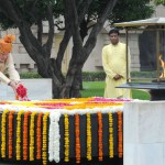 In this handout photograph released by The Indian Press Informatuion Bureau (PIB) on August 15, 2015, India's Prime Minister Narendra Modi (L) is watched by an official as he scatters rose petals while paying his respects at the Samadhi of Mahatma Gandhi at Rajghat in New Delhi, on the occasion of India's Independence Day.