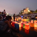 Paper lanterns float in the Motoyasu river in front of the Atomic Bomb Dome (background) in Hiroshima on August 6, 2015.