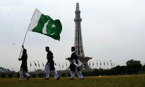 People holding national flag at Minar e Pakistan in connection to Independence Day, in Lahore