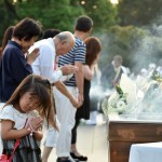 People pray for the victims of the 1945 atomic bombing, at the Peace Memorial Park in Hiroshima on August 6, 2015.