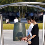 People ring a bell to mark the moment when an atom bomb exploded over Hiroshima 70 years ago during a commemoration ceremony at Peace Memorial Park in Hiroshima, August 6, 2015. The US dropped an atomic bomb at Hiroshima on August 6, 1945, killing about 140,000 by the end of the year in a city of 350,000 residents. It was the world's first nuclear attack.