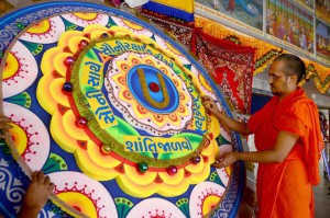 Priest of Kumkum Swaminarayan temple gives final touches to a huge ‘Rakhi’ on a day before Raksha Bandhan in Ahmedabad on August 28, 2015. The rakhi had various peace messages in view of the recent incidents of violence