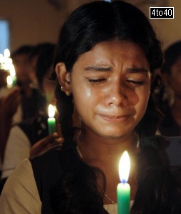 Schoolgirls hold candles as they sit in front of a portrait of former President APJ Abdul Kalam during a prayer ceremony in Chennai on July 28, 2015.
